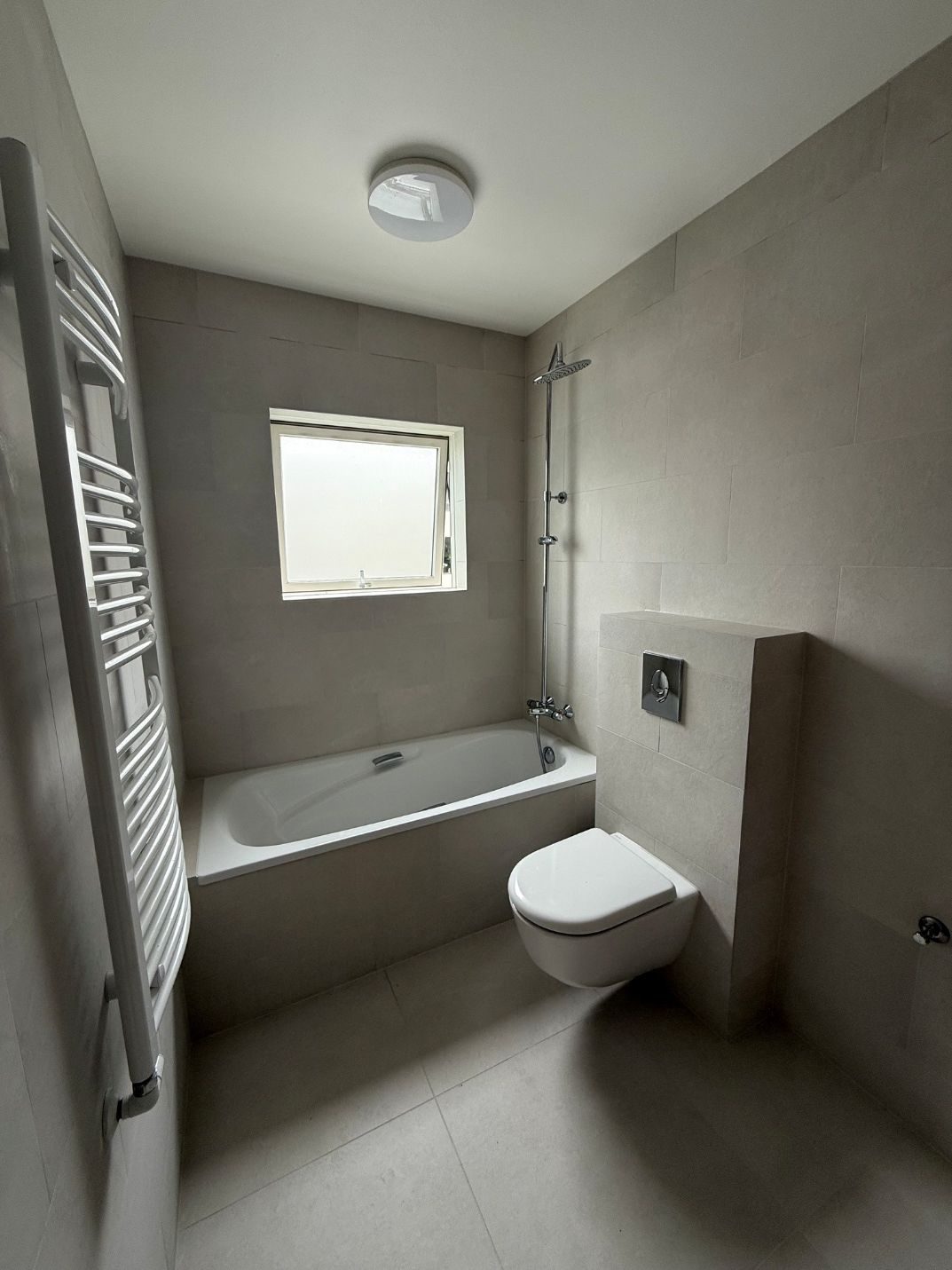 Bathroom 2 — after, grey tiles + rain shower + heated towel rail