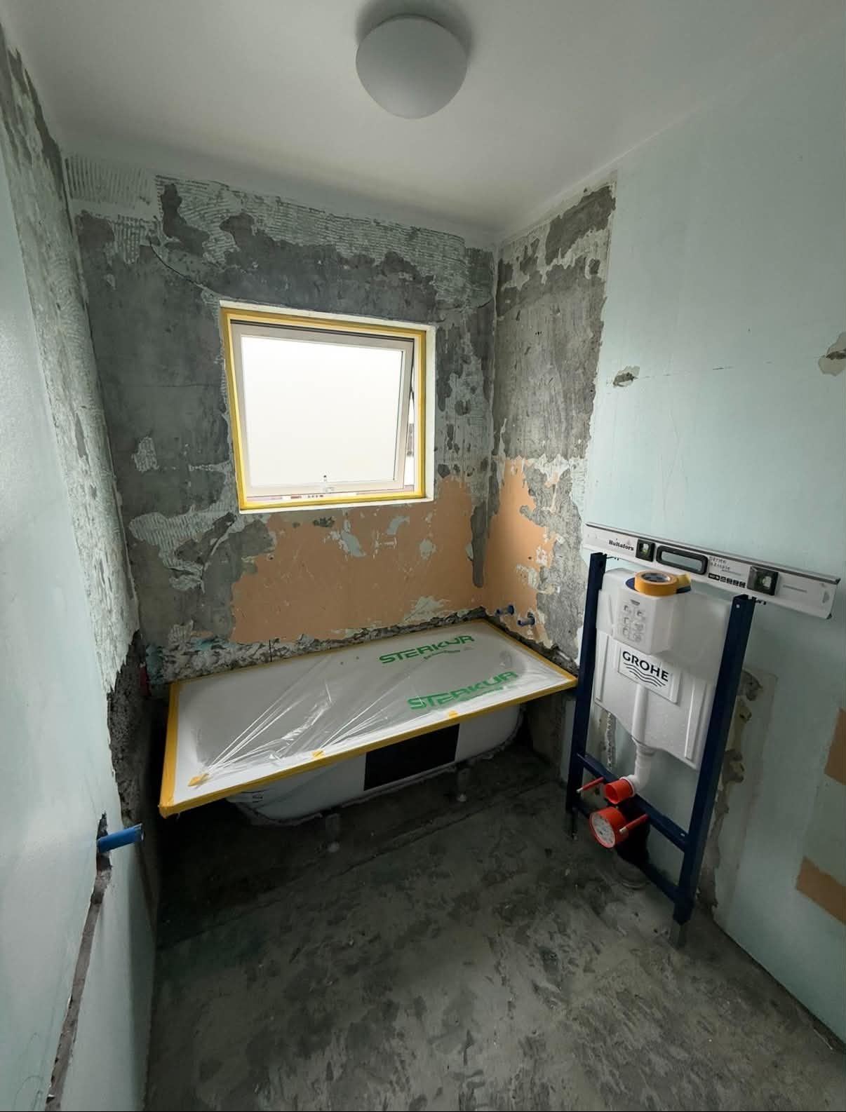 Bathroom 2 — before, demolition with new bathtub wrapped in STERKUR